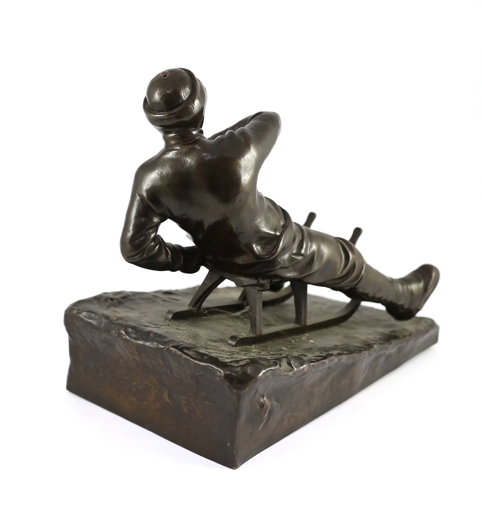 A late 19th / early 20th century German bronze model of a tobogganist, 30cm high 32cm long